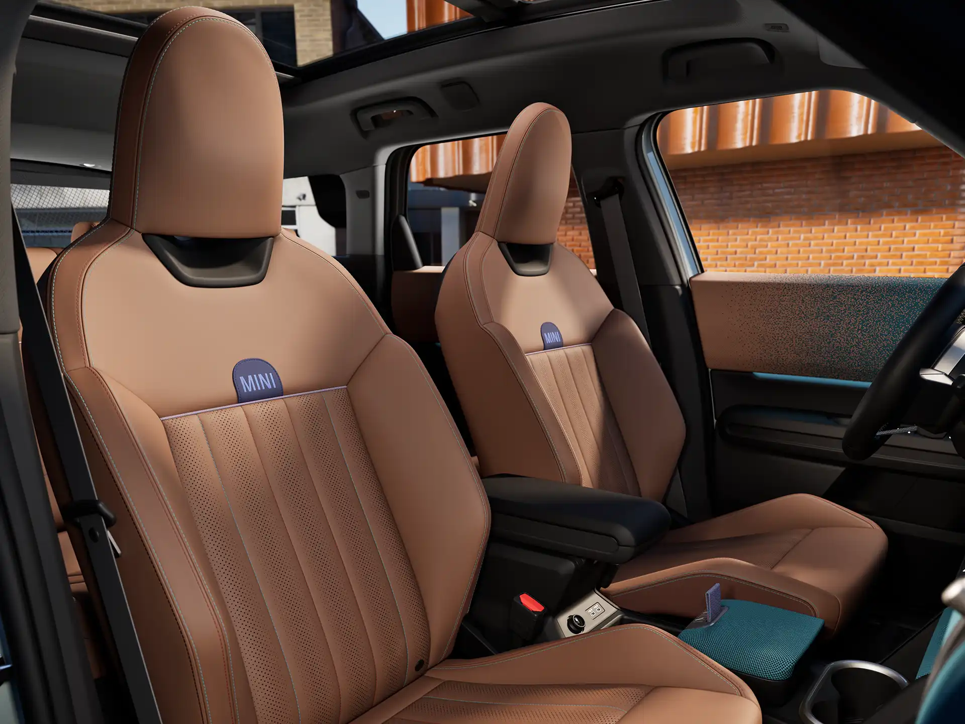 Interior perspective of the MINI Countryman is showing the dashboard, steering wheel, round display, panorama glassroof and back of the frontseats.